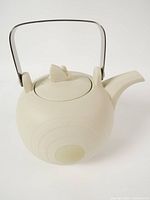 Front three-quarter view of Hornsea Concept cream matte teapot with wire handle and lid
