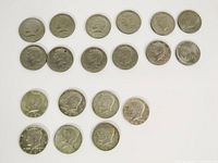 Nineteen Kennedy half dollar coins arranged in rows on white background