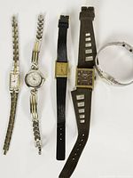 All five watches laid out showing cases and straps