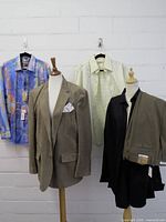 Full view of five apparel pieces on hangers and mannequin forms