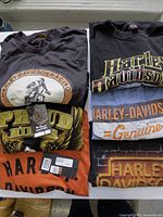 Six folded graphic T-shirts in two stacks showing front graphics and colors