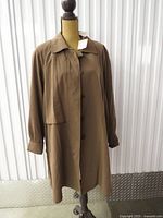 Full front view of brown overcoat on dress form showing overall style and length