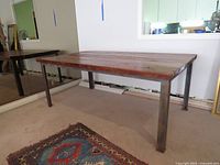 Full view of table angled left showing barnboard top and steel legs