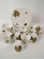 Full lot showing cups, saucers, plates, cake plate, and creamer