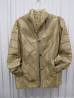 Front view of beige shearling leather jacket hung on hanger