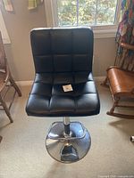 Front view of black synthetic leather bar stool showing tufted seat/back and overall design