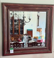 Front view of square burgundy wood framed mirror