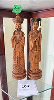 Front view of both carved wood Emperor and Empress figurines on bases