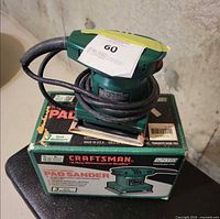 Sander resting on original box showing overall item