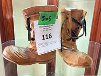 Front view of both wooden boots showing size tag and leather laces