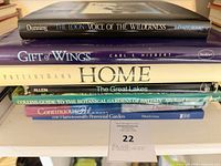 Stack of six hardcover books on shelf with visible titles