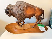 Full view of bison sculpture on base with plaque visible