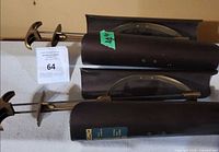 Two Jana plastic and brass-tone boot shapers lying side by side showing mechanisms and size sticker