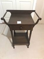 Full view of accent table showing overall design, drawer, lower shelf, and handles