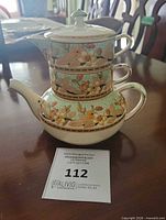 Stacked view of teapot and cup showing pattern and form