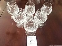 Full set of six Stuart Crystal glasses on table