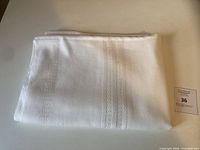 Folded white linen tablecloth on table