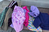 Overview of assorted fabric pieces spread on bench