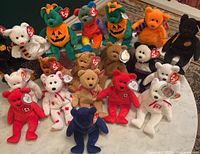 All 18 bears arranged on table showing variety of colors and tags