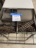 Overall view of two metal boxes on rack, filled with drill bits