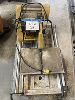 Full view of Brutus tile saw on stand showing cutting tray and power cord