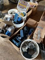 Buckets and boxes filled with blue plastic boxes and metal boxes