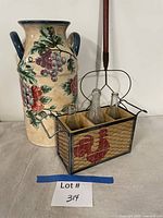 Front view of all items: umbrella stand, caddy with bottles, rug beater