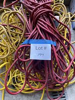 Pile of red extension cords atop yellow string lights
