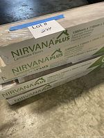 Stack of Nirvana Plus laminate flooring boxes showing brand and dimensions