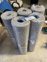 Five sealed underlayment rolls standing upright