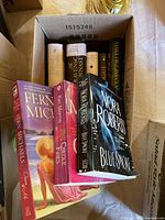 Box containing five hardcover novels and three paperbacks