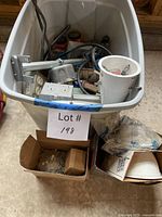 Tote containing assorted metal boxes, blue boxes, wire nut jars, cords, lampholder, boxes of wall plates and light globe