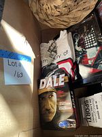 Box interior showing T-shirt, DVD tin, framed photo, coaster box