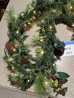 Full view of lighted evergreen garland on countertop