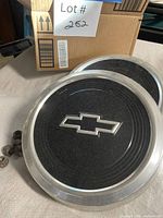 Pair of Chevrolet hubcaps with lug nuts visible