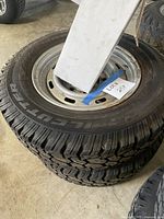 Two stacked Trail Cutter Tempra Radial R/T tires mounted on steel wheels
