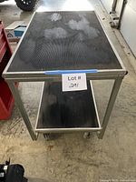 Full front view of two-shelf stainless cart on wheels