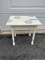 front view of cream side table with blue stencils
