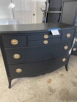 Full front view of black six-drawer dresser
