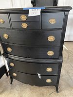 Full view of black 8-drawer highboy dresser with brass oval pulls