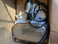 Iron underside with cord and paperwork in box