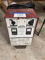 Full view of red wheeled battery charger with front panel and cables