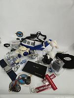 Entire lot overview showing bag, clock, tin, toys, keychains, tags