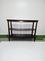 Front view of three-tier console table against white wall