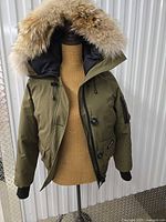 Front view of olive Canada Goose Chilliwack Bomber on mannequin showing fur hood and front zip
