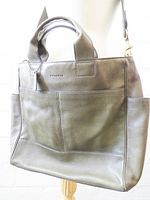 Front view of Coach City Tote showing exterior front pocket, hang tag and handles