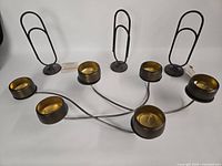 overhead view of metal candle holder with six cups and four clip stands