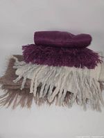 Stacked view of three fringed scarves showing colors and texture