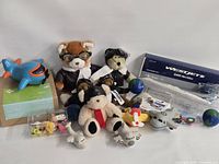 Group shot showing all aviation-themed items including boxed WestJet model, plush toys, stress toys, mini aircraft