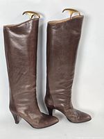 Full side view of both brown knee-high leather boots on stands